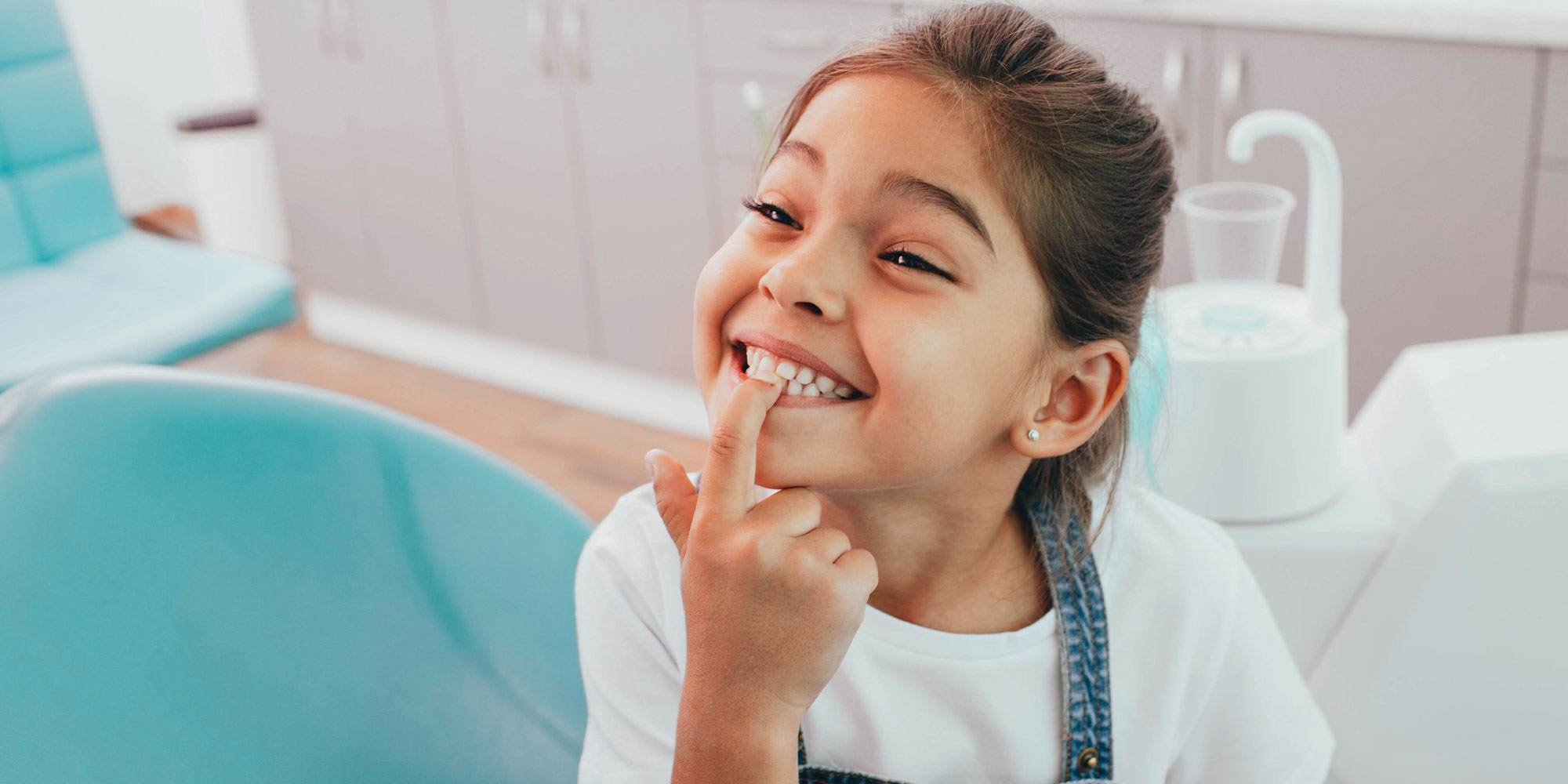 Kid at dentist pointing at teeth